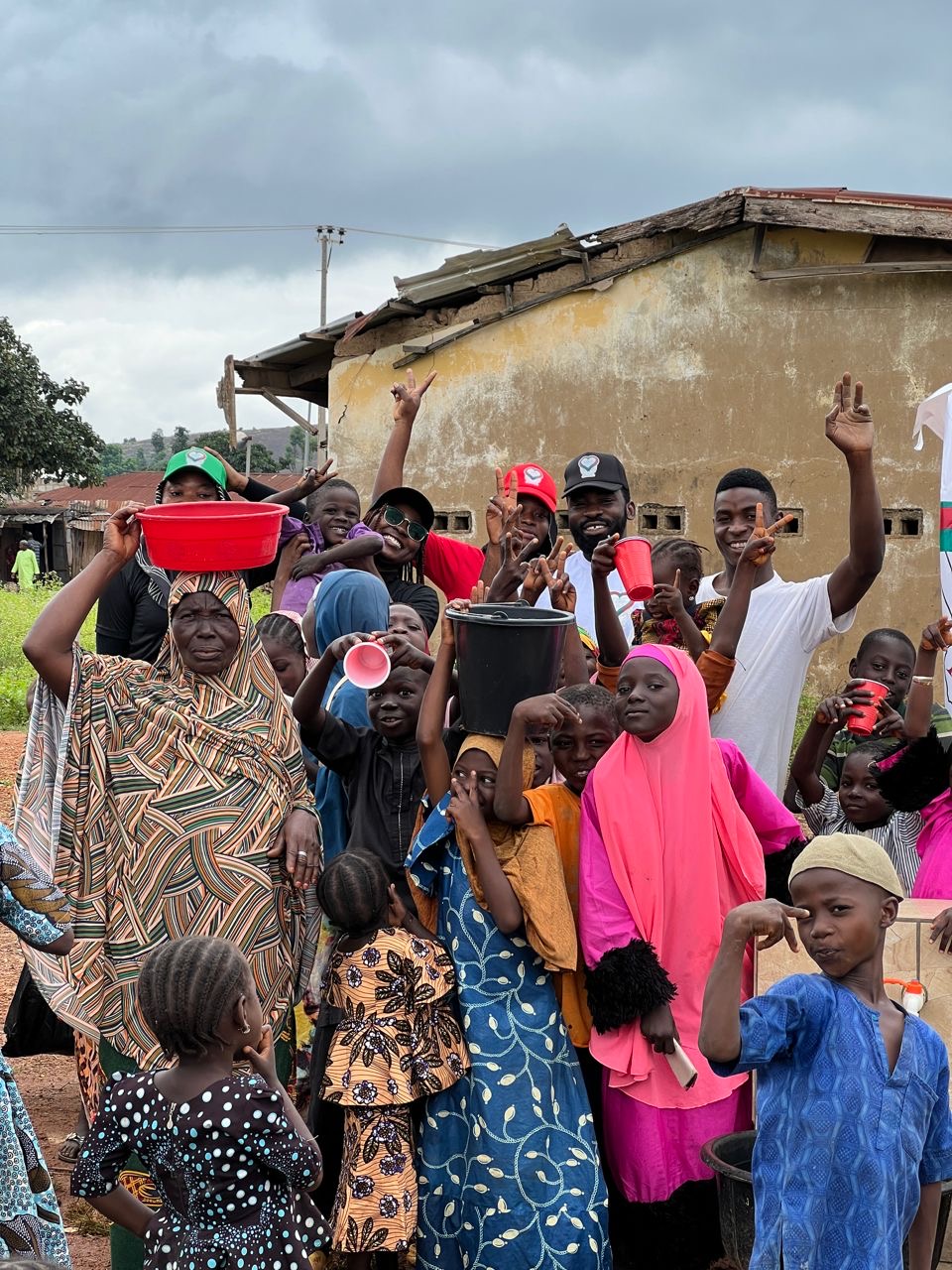 Community members and foundation volunteers gathered in front of a building during the Shere Community Water Project in Abuja